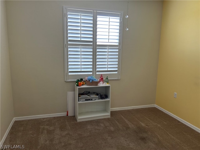 spare room featuring dark colored carpet