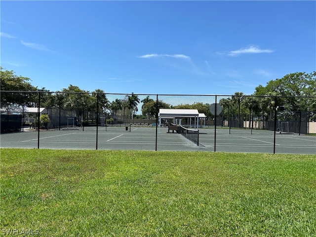 view of tennis court with a yard