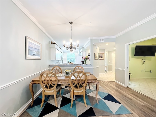 tiled dining area featuring a chandelier and crown molding