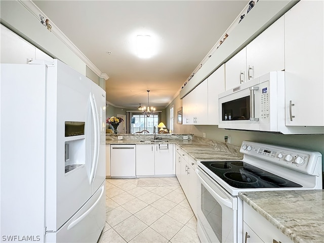 kitchen with white appliances, white cabinetry, hanging light fixtures, and an inviting chandelier