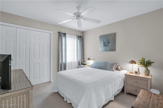 bedroom with ceiling fan, a closet, and light carpet