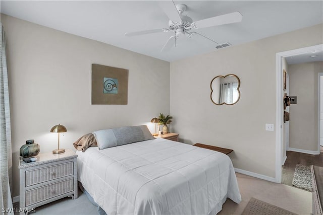 bedroom with baseboards, a ceiling fan, visible vents, and light colored carpet