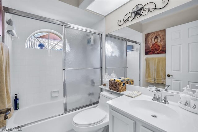 bathroom with vanity, combined bath / shower with glass door, and toilet