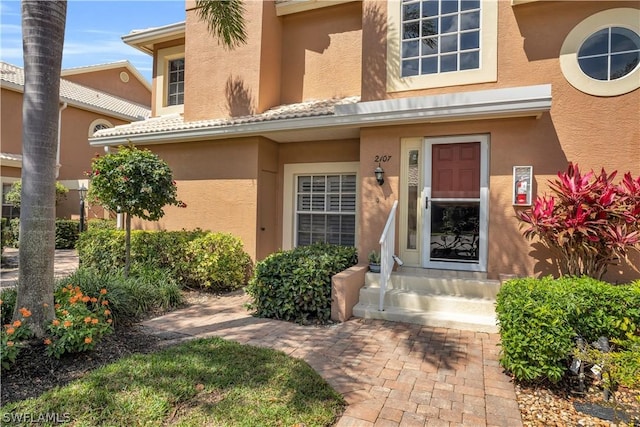 entrance to property featuring stucco siding