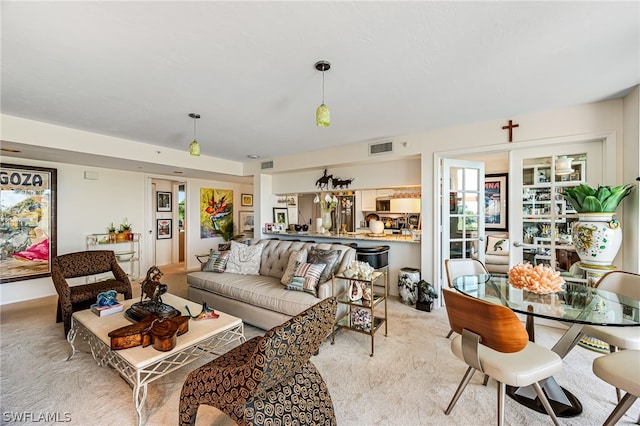 living area featuring light carpet and visible vents