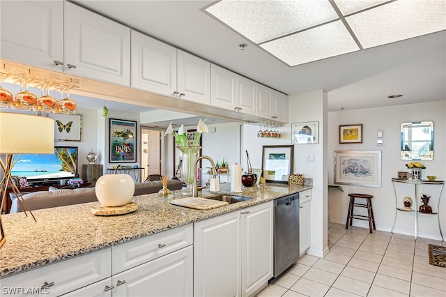 kitchen featuring white cabinets, dishwasher, a sink, and light stone countertops