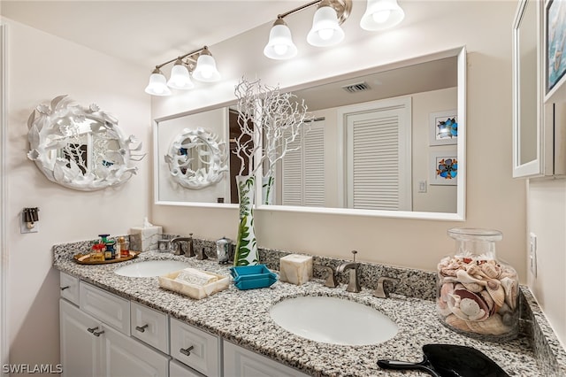 full bathroom featuring double vanity, a closet, visible vents, and a sink