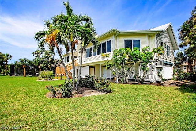 back of property with stairway and a yard