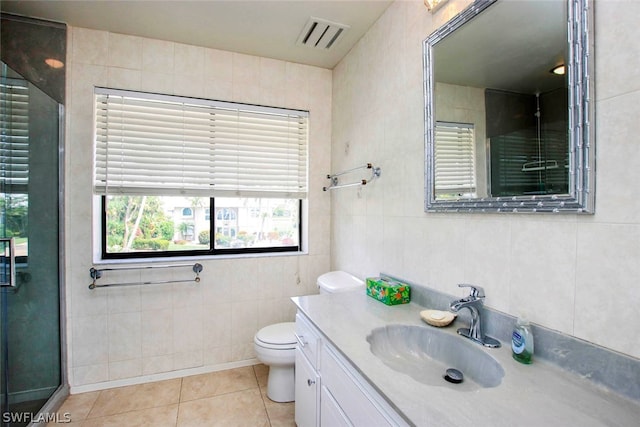 bathroom with vanity, visible vents, tile patterned floors, toilet, and tile walls