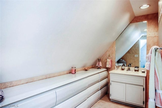 bathroom with vanity and lofted ceiling