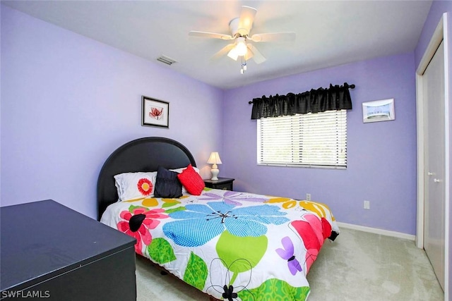 carpeted bedroom featuring a closet, visible vents, a ceiling fan, and baseboards