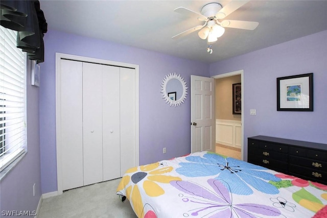 bedroom featuring a closet, light colored carpet, and ceiling fan