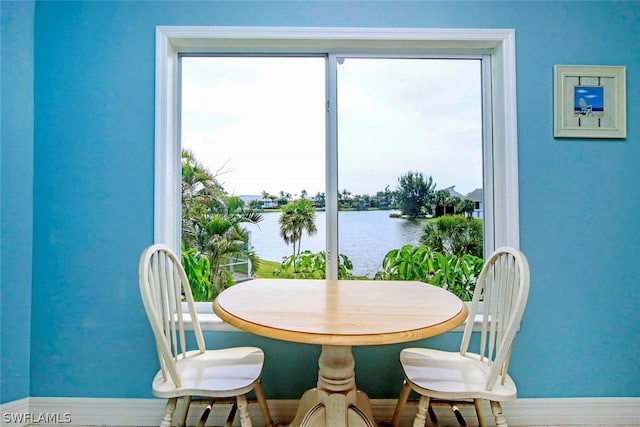 dining room with baseboards and a water view