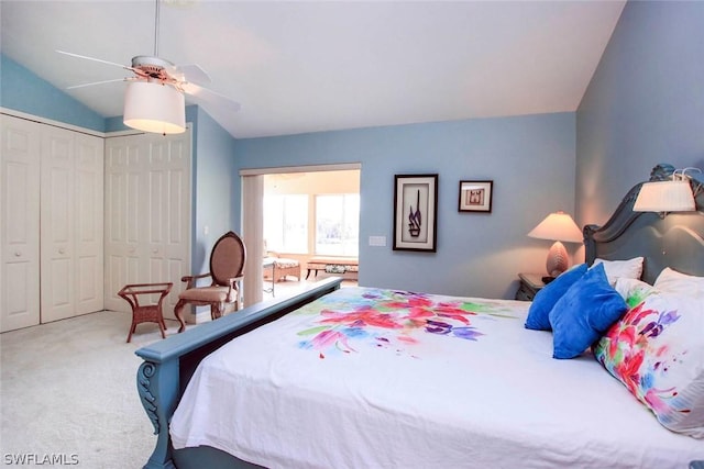 carpeted bedroom with a closet, lofted ceiling, and ceiling fan