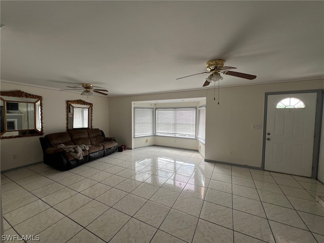 unfurnished living room with light tile floors, crown molding, and ceiling fan