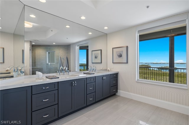 bathroom featuring vanity, a water view, and a tile shower