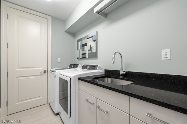 laundry area featuring cabinets, sink, and washing machine and dryer