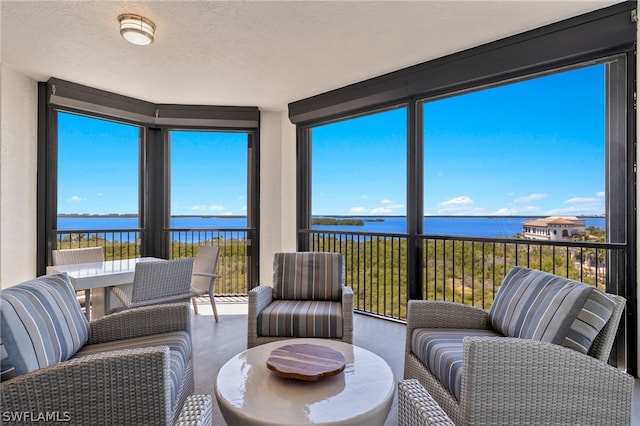 sunroom featuring a water view