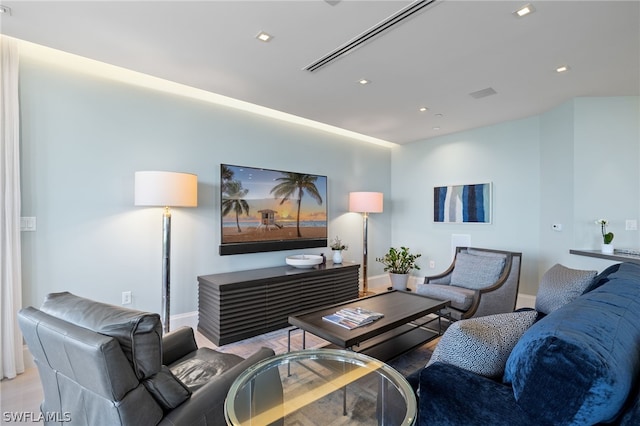 living room with baseboards, wood finished floors, and recessed lighting