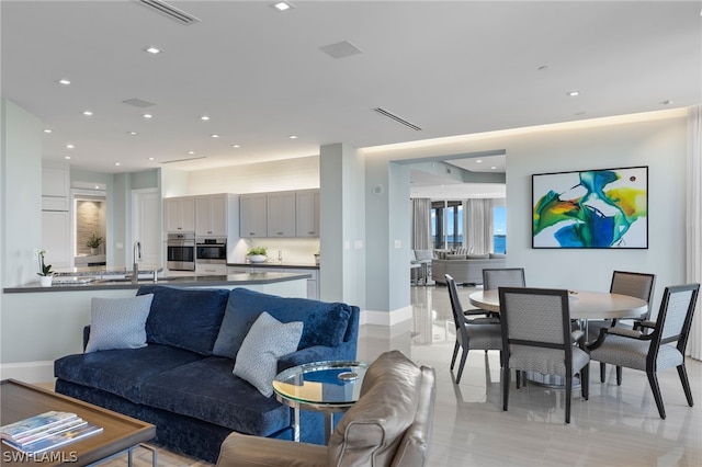 living area featuring baseboards, visible vents, and recessed lighting