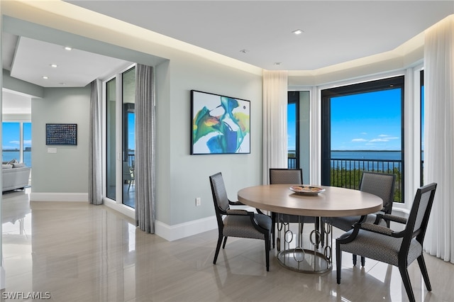 dining room featuring a water view and a wealth of natural light