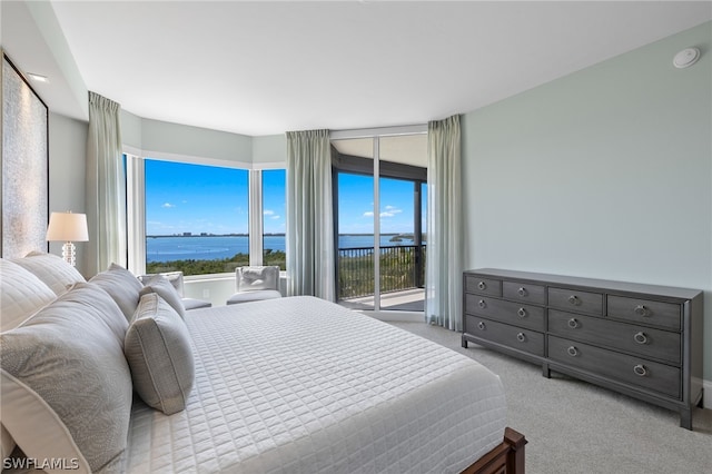 carpeted bedroom featuring a water view and access to outside