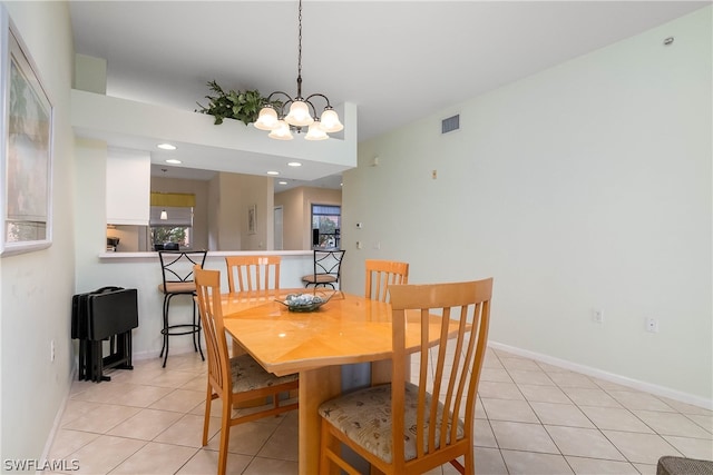 dining room featuring light tile floors and a notable chandelier