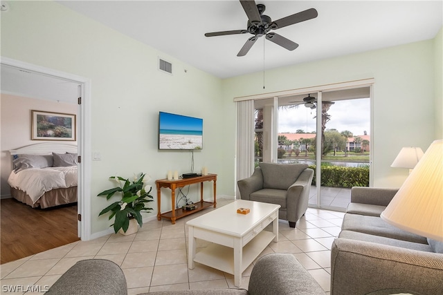 living room featuring light tile floors and ceiling fan