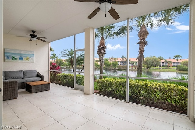 sunroom with a water view and ceiling fan