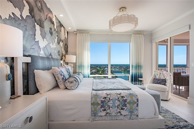 bedroom featuring a water view, access to exterior, and crown molding