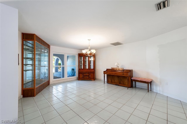 tiled empty room featuring an inviting chandelier