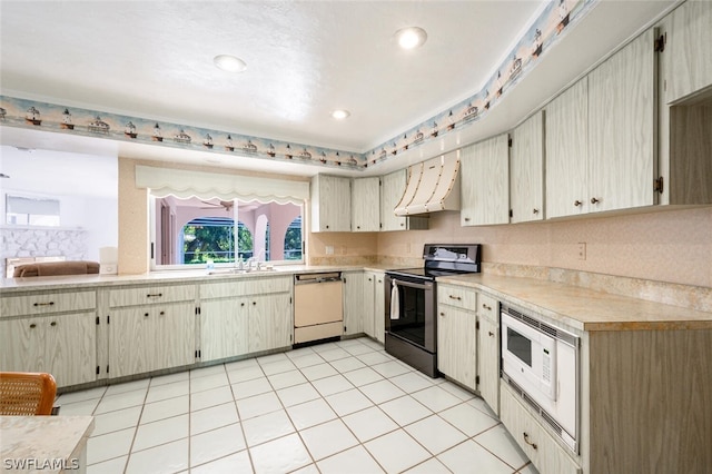 kitchen with light tile floors, premium range hood, and white appliances