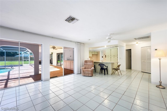 unfurnished living room with ceiling fan and light tile floors