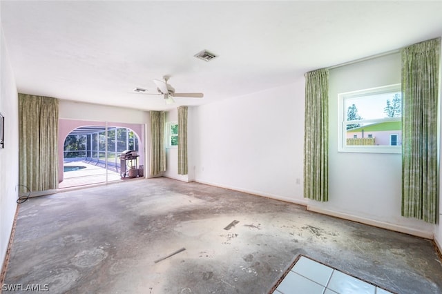 spare room with ceiling fan and concrete floors