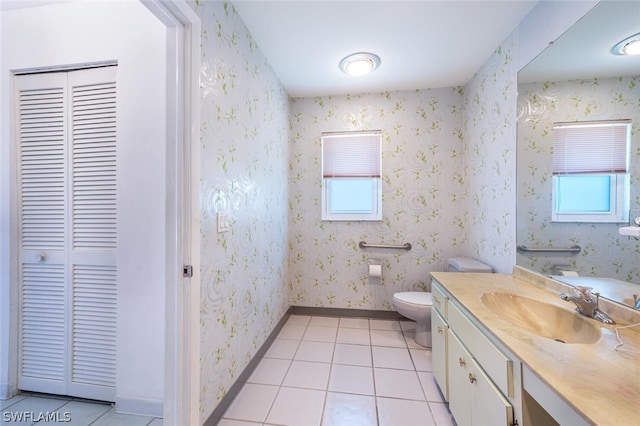 bathroom featuring toilet, tile floors, plenty of natural light, and vanity