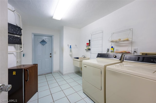 washroom with light tile flooring, sink, washer and dryer, and washer hookup