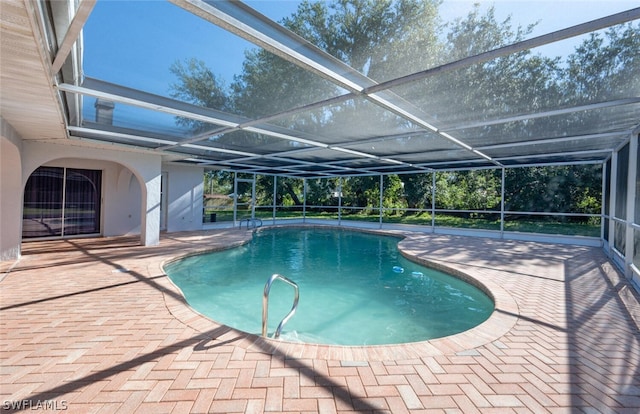 view of swimming pool featuring glass enclosure and a patio area