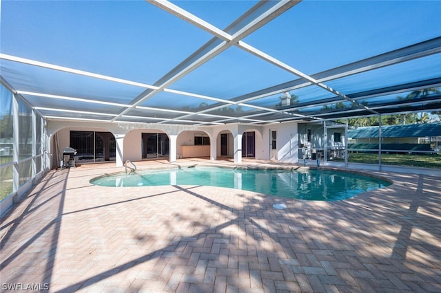 view of swimming pool featuring a patio area and glass enclosure