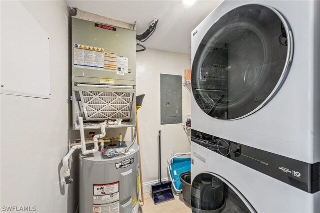 laundry area with water heater, stacked washer / drying machine, and light hardwood / wood-style flooring