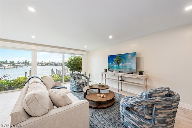 living room featuring a water view and light hardwood / wood-style flooring