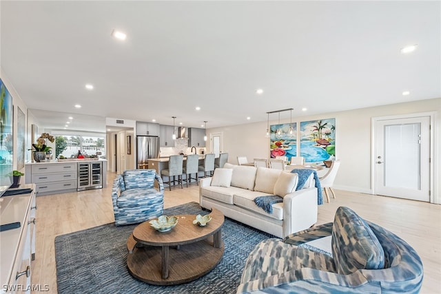 living room featuring wine cooler and light hardwood / wood-style flooring