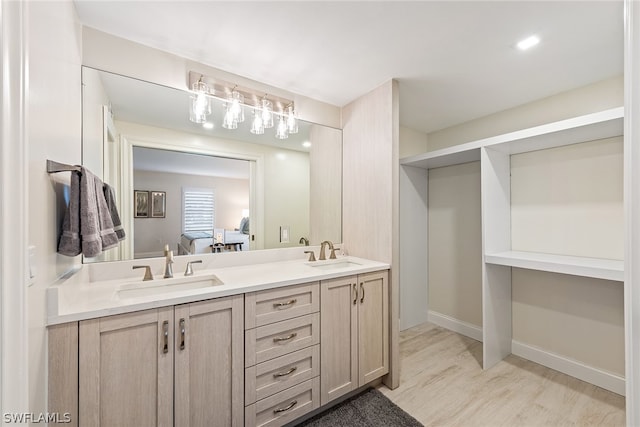 bathroom with dual vanity and hardwood / wood-style flooring