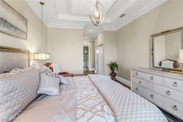 bedroom with ornamental molding, ensuite bathroom, wood-type flooring, and a raised ceiling