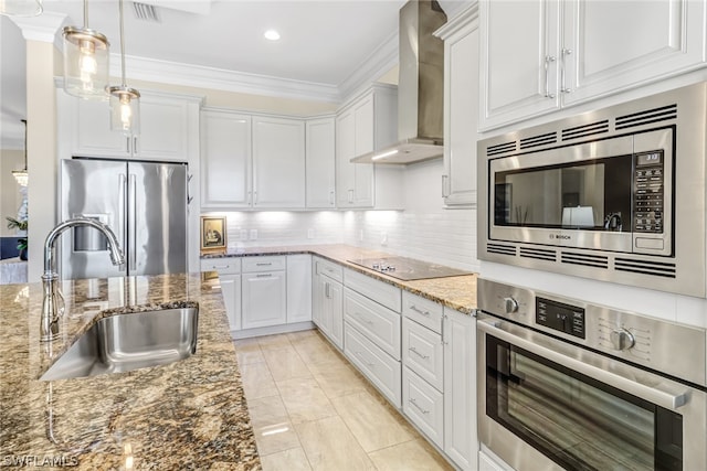 kitchen with wall chimney exhaust hood, stone countertops, appliances with stainless steel finishes, and white cabinetry