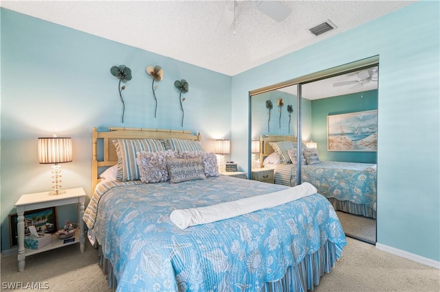 bedroom with carpet floors, a closet, visible vents, a ceiling fan, and a textured ceiling