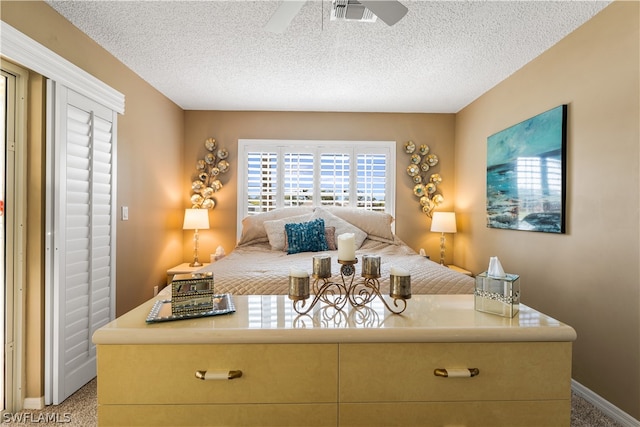 bedroom with ceiling fan, light carpet, and a textured ceiling