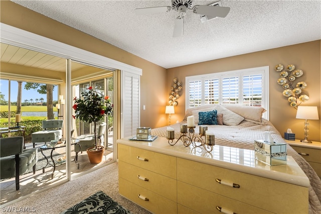 bedroom with a textured ceiling, ceiling fan, access to exterior, and light carpet