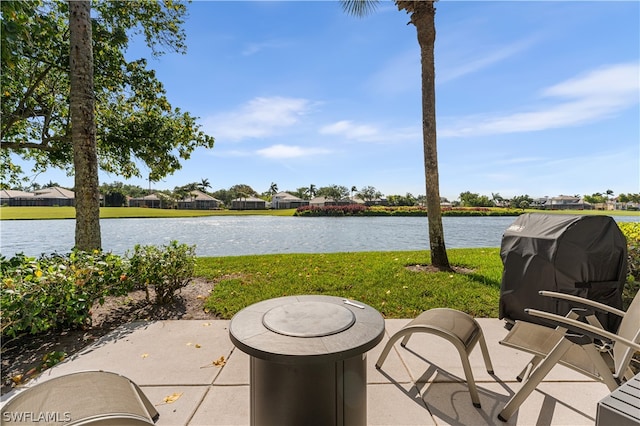 view of patio with a grill and a water view