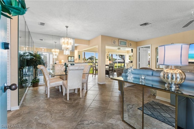 dining space featuring ceiling fan with notable chandelier, a textured ceiling, and visible vents