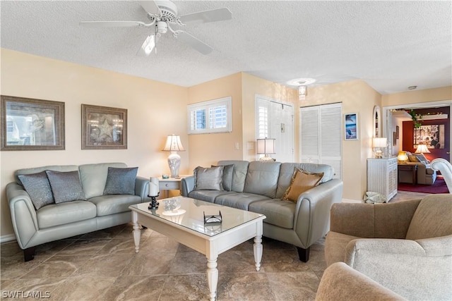 living area with a ceiling fan and a textured ceiling